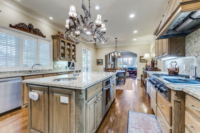 5930 Desco Dr, Dallas, TX 75225 - kitchen featuring a chandelier, appliances with stainless steel finishes, custom range hood, a center island with sink, and decorative backsplash