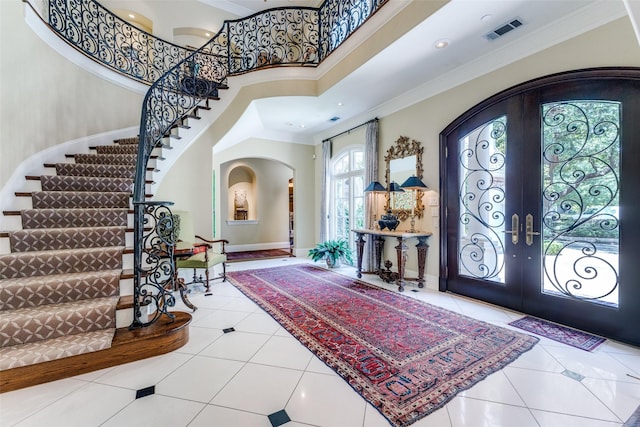 5930 Desco Dr, Dallas, TX 75225 - foyer entrance featuring french doors, arched walkways, ornamental molding, stairway, and tile patterned floors
