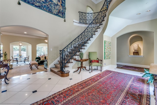 5930 Desco Dr, Dallas, TX 75225 - tiled foyer entrance featuring arched walkways, crown molding, stairway, and recessed lighting