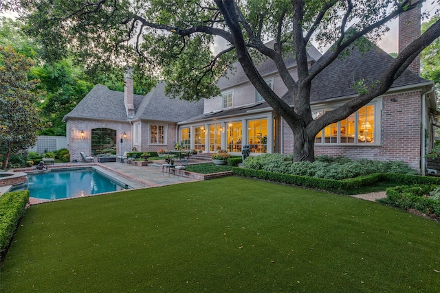 5930 Desco Dr, Dallas, TX 75225 - back of property featuring brick siding, a chimney, a patio, and a yard