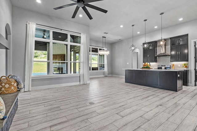 521 Echo Glade Ct, Azle, TX 76020 - kitchen with ceiling fan, light countertops, electric stove, dark cabinetry, and wall chimney range hood
