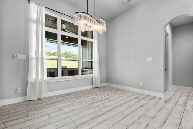 521 Echo Glade Ct, Azle, TX 76020 - spare room featuring arched walkways, light wood finished floors, and a chandelier