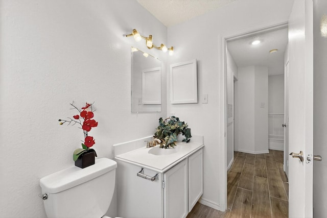 10320 Wood Heights Dr, Dallas, TX 75227 - bathroom with vanity, wood finished floors, and a textured ceiling