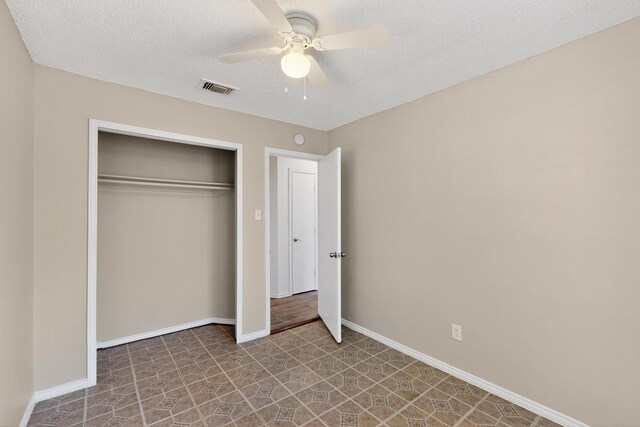 10320 Wood Heights Dr, Dallas, TX 75227 - unfurnished bedroom featuring a closet, a ceiling fan, and a textured ceiling