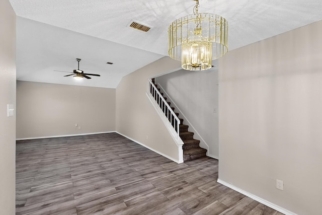 10320 Wood Heights Dr, Dallas, TX 75227 - unfurnished living room with stairs, wood finished floors, ceiling fan, and a chandelier