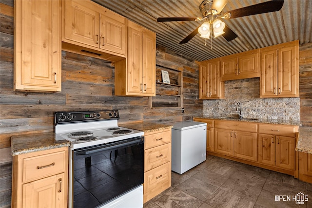 894 W Moonshine Rd, Seymour, TX 76380 - kitchen with white electric stove, wood walls, ceiling fan, and light brown cabinets