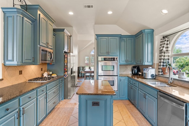 1740 Greenwood Ct, Prosper, TX 75078 - kitchen with stainless steel appliances, a center island, vaulted ceiling, plenty of natural light, and backsplash