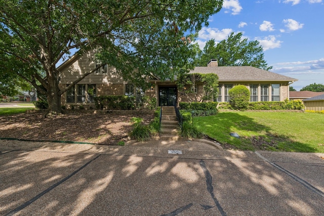 3901 Old Mill Rd, Waco, TX 76710 - view of front facade with brick siding, a front yard, and a chimney