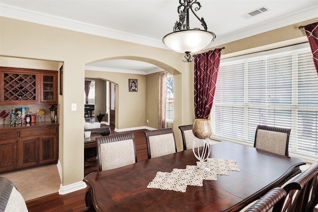 3217 Tearose Dr, Richardson, TX 75082 - dining space featuring arched walkways, wood finished floors, and ornamental molding