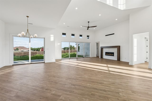 4930 Magnolia Trl, Midlothian, TX 76065 - unfurnished living room featuring a high ceiling, a lit fireplace, wood finished floors, recessed lighting, and a ceiling fan
