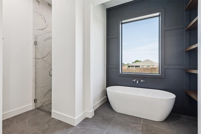 4930 Magnolia Trl, Midlothian, TX 76065 - full bath with marble look tile flooring, healthy amount of natural light, a freestanding tub, and a marble finish shower