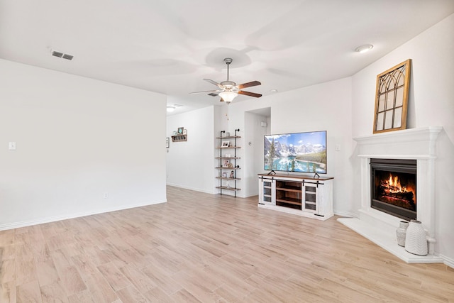 813 Evergreen St, Princeton, TX 75407 - unfurnished living room with a warm lit fireplace, ceiling fan, and light wood-type flooring