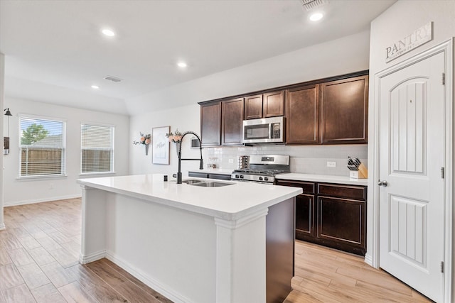 813 Evergreen St, Princeton, TX 75407 - kitchen with appliances with stainless steel finishes, backsplash, a kitchen island with sink, light countertops, and dark brown cabinets