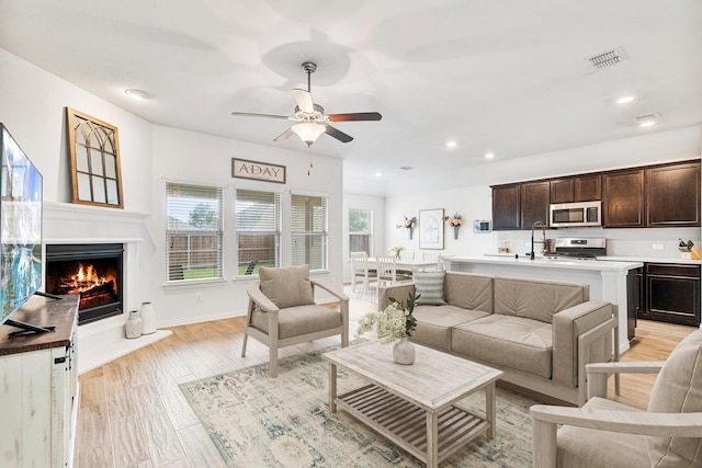 813 Evergreen St, Princeton, TX 75407 - living area with ceiling fan, recessed lighting, and a lit fireplace