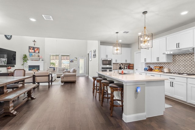 332 Augusta Ct, Oak Point, TX 75068 - kitchen featuring under cabinet range hood, stainless steel appliances, backsplash, an island with sink, and recessed lighting