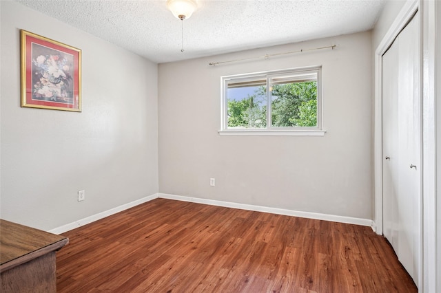 1822 Lakecrest Ct, Carrollton, TX 75006 - unfurnished bedroom with a closet, wood finished floors, and a textured ceiling