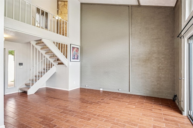 1822 Lakecrest Ct, Carrollton, TX 75006 - unfurnished room featuring a high ceiling, wood finished floors, brick wall, and stairway