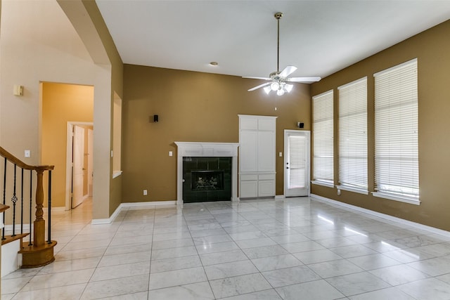 3304 Springbridge Ln, Plano, TX 75025 - unfurnished living room featuring a ceiling fan, stairs, a fireplace, and a towering ceiling