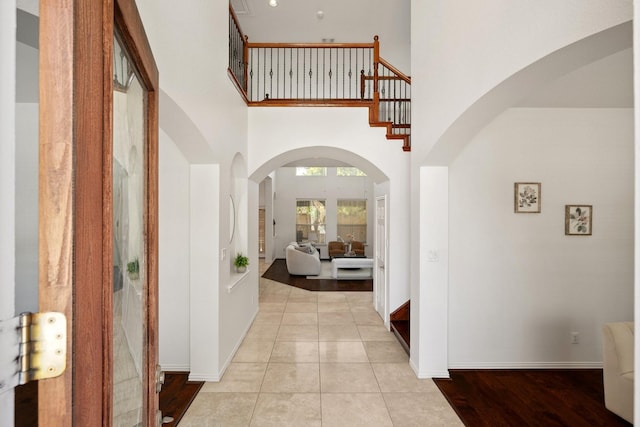 1205 Apache Lake Dr, Carrollton, TX 75010 - entryway featuring a high ceiling, arched walkways, stairway, and light tile patterned floors