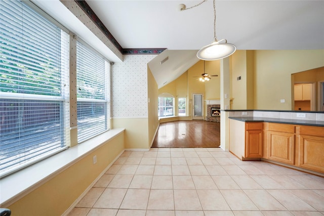 8201 Fountain Ridge Dr, Plano, TX 75025 - kitchen with dark countertops, ceiling fan, pendant lighting, light tile patterned floors, and vaulted ceiling