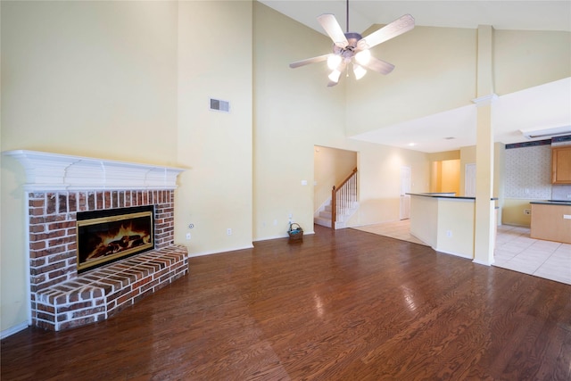 8201 Fountain Ridge Dr, Plano, TX 75025 - unfurnished living room with light wood-style floors, a fireplace, ceiling fan, stairway, and high vaulted ceiling
