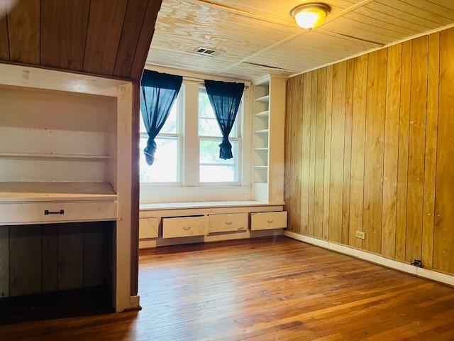 106 Lawrence Ave, Terrell, TX 75160 - bonus room with wood walls, wood ceiling, hardwood / wood-style flooring, and built in features