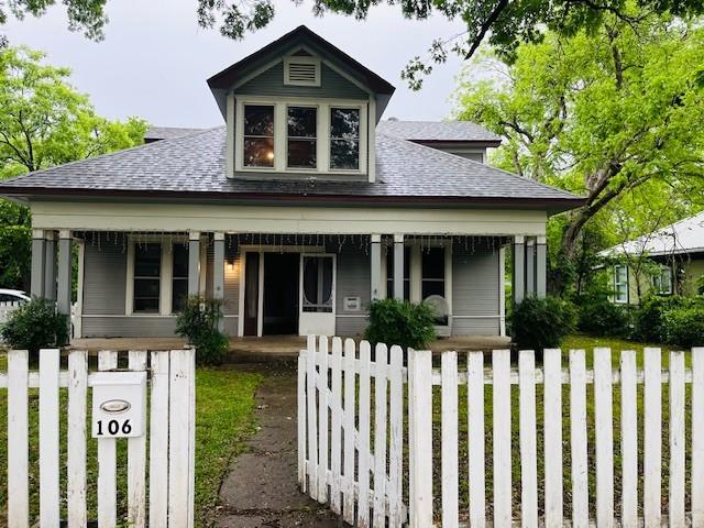 106 Lawrence Ave, Terrell, TX 75160 - bungalow featuring a porch, roof with shingles, and a fenced front yard