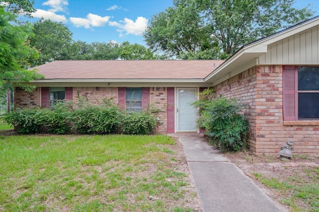 6179 State Highway 31 E, Murchison, TX 75778 - view of front of home with brick siding, a front yard, a shingled roof, and board and batten siding