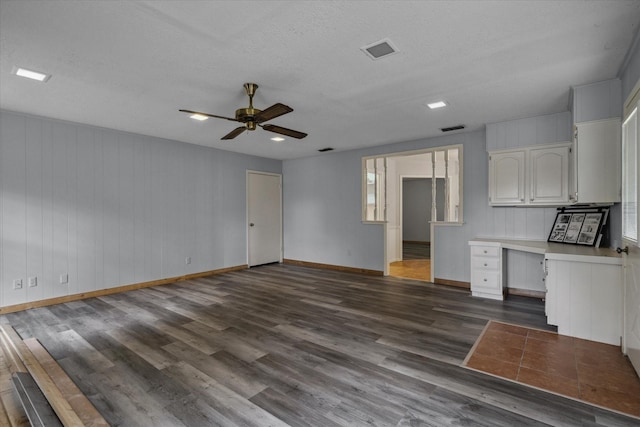 6179 State Highway 31 E, Murchison, TX 75778 - unfurnished living room with dark wood-style floors, ceiling fan, an office area, and a textured ceiling