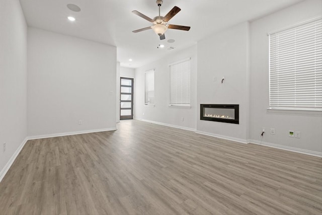 2105 Hazel Lily Run, Mesquite, TX 75181 - unfurnished living room with ceiling fan, light wood-style floors, a glass covered fireplace, and recessed lighting