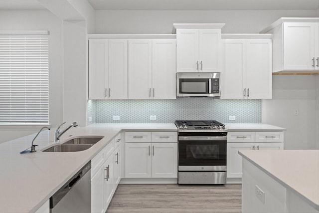 2105 Hazel Lily Run, Mesquite, TX 75181 - kitchen featuring appliances with stainless steel finishes, white cabinetry, light countertops, and backsplash