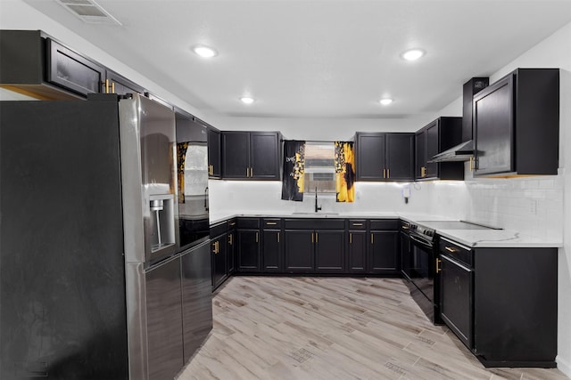 1035 Warden St, Benbrook, TX 76126 - kitchen featuring stainless steel fridge, black electric range, tasteful backsplash, recessed lighting, and light wood-style flooring