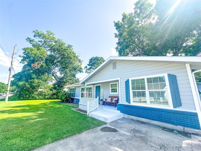 909 Baird St, Cleburne, TX 76033 - view of front facade with covered porch, brick siding, and a front lawn