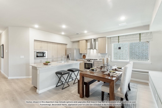 937 Kingbird Ln, Alvarado, TX 76009 - kitchen with appliances with stainless steel finishes, wall chimney exhaust hood, light wood-type flooring, a kitchen island with sink, and recessed lighting