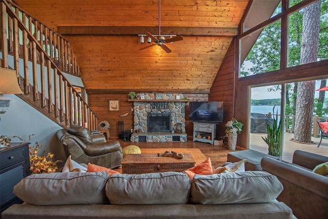 329 Hickory Hill Ln, Scroggins, TX 75480 - living area featuring wooden walls, wood finished floors, a ceiling fan, a wood ceiling with exposed beams, and stairway