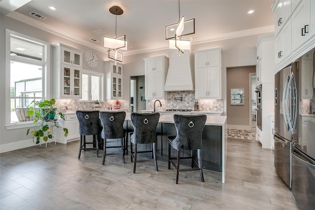720 Glade Park Ct, Azle, TX 76020 - kitchen with stainless steel appliances, an island with sink, light countertops, a breakfast bar, and decorative backsplash
