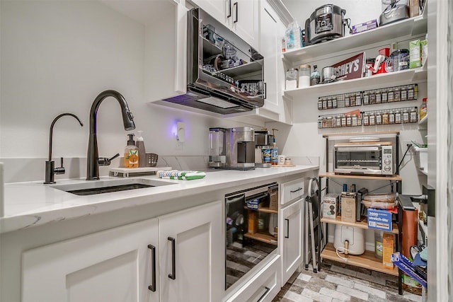 720 Glade Park Ct, Azle, TX 76020 - kitchen with white cabinetry, wine cooler, light stone counters, brick patterned flooring, and open shelves
