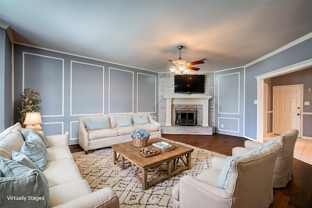 1015 Midnight Pass, Rockwall, TX 75087 - living room with a decorative wall, ceiling fan, a fireplace, wood finished floors, and crown molding