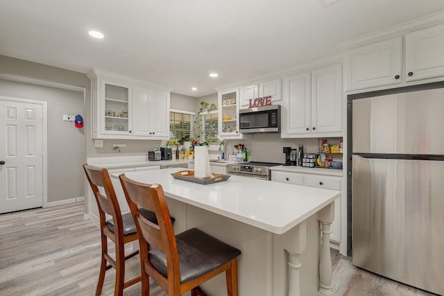621 New Market Rd, Mesquite, TX 75149 - kitchen with appliances with stainless steel finishes, light countertops, white cabinets, a breakfast bar, and recessed lighting