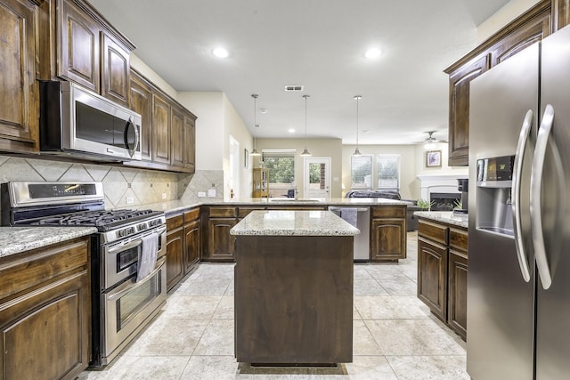 2600 Canyon Wren Ln, Fort Worth, TX 76244 - kitchen with stainless steel appliances, a peninsula, a kitchen island, a ceiling fan, and backsplash