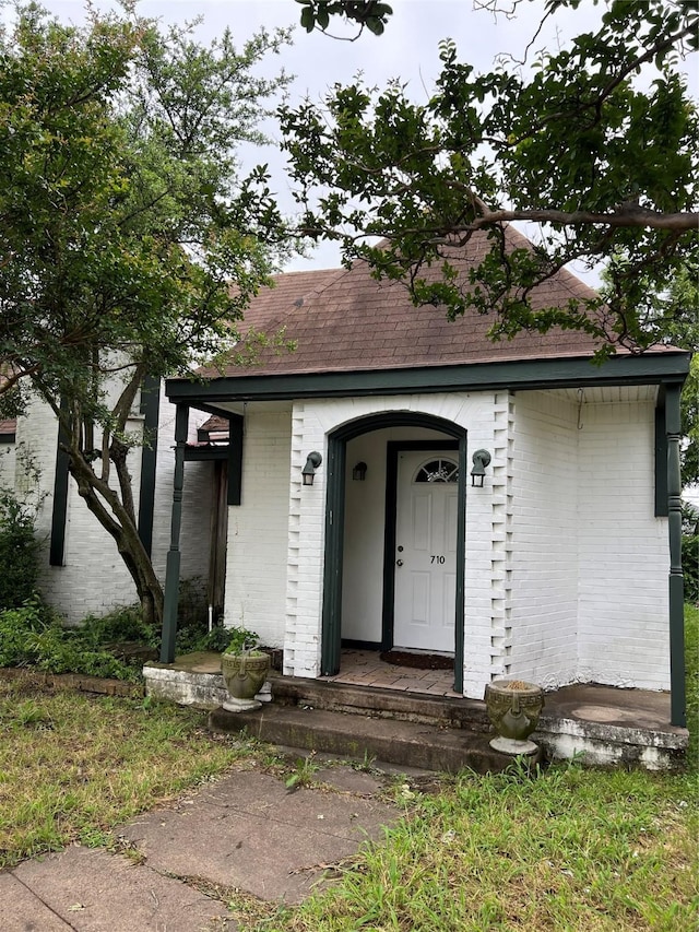 710 W Main St, Denison, TX 75020 - view of front of property with brick siding and roof with shingles