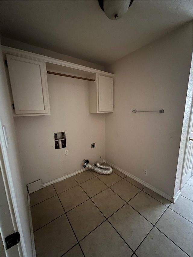 710 W Main St, Denison, TX 75020 - laundry room with electric dryer hookup, cabinet space, light tile patterned flooring, and washer hookup