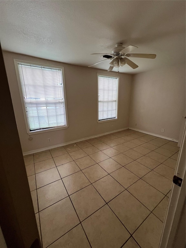 710 W Main St, Denison, TX 75020 - empty room with light tile patterned floors, a ceiling fan, and a textured ceiling