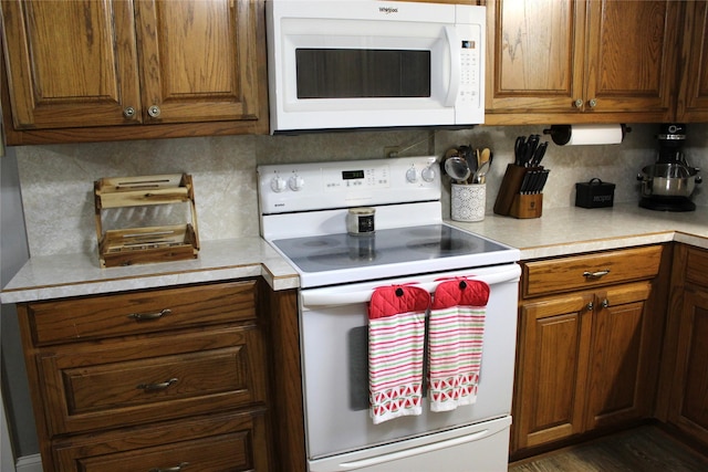 590 N Charlotte Ave, Stephenville, TX 76401 - kitchen with white appliances, light countertops, backsplash, and brown cabinets