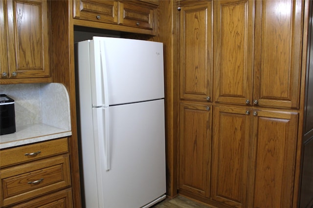 590 N Charlotte Ave, Stephenville, TX 76401 - kitchen featuring freestanding refrigerator, brown cabinetry, and light countertops