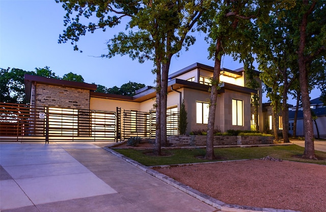 548 Oak Grove Ln, Coppell, TX 75019 - contemporary house with concrete driveway, stone siding, and a gate