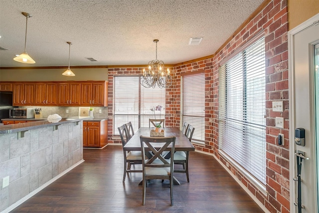 4307 Foxborough Trl, Arlington, TX 76001 - dining area with a textured ceiling, dark wood-style floors, a chandelier, healthy amount of natural light, and brick wall