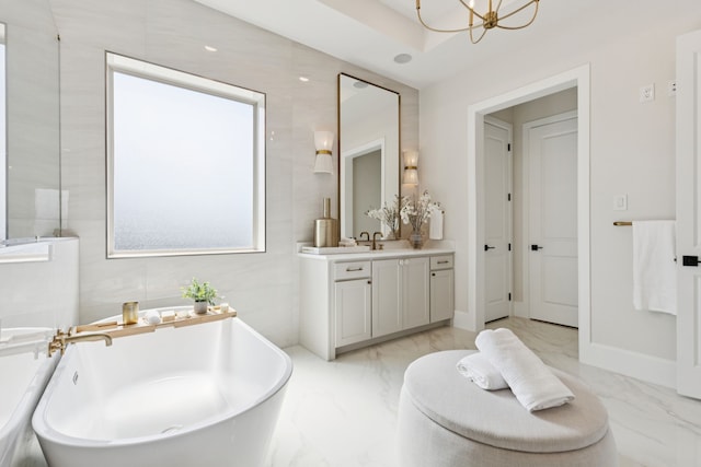 4400 Honeyvine Ln, Prosper, TX 75078 - full bath with marble tiled floors, vanity, a freestanding bath, and a chandelier