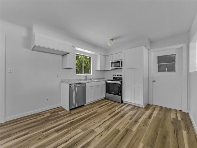 202 E Rentz St, Weatherford, TX 76086 - kitchen featuring appliances with stainless steel finishes, white cabinetry, light countertops, and light wood-type flooring