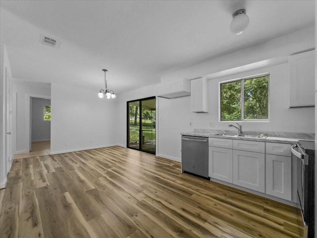 202 E Rentz St, Weatherford, TX 76086 - kitchen with stainless steel dishwasher, a chandelier, light wood finished floors, and white cabinets